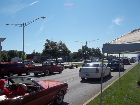 1970 Ford Ranchero - A variety of vehicles are seen on a sunny day, possibly during a car show or parade.