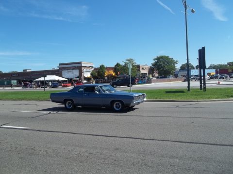 1970 Ford Ranchero - A blue 1968 Ford Torino coupe is seen driving on a road with buildings in the background.