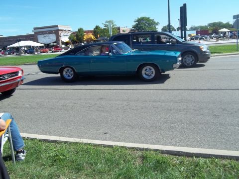 1970 Ford Ranchero - A teal 1968 Dodge Charger with a black vinyl top is seen from the side, driving alongside other vehicles.