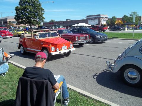 1970 Ford Ranchero - An orange convertible off-road vehicle is parked on the street, with other cars and spectators in the background.