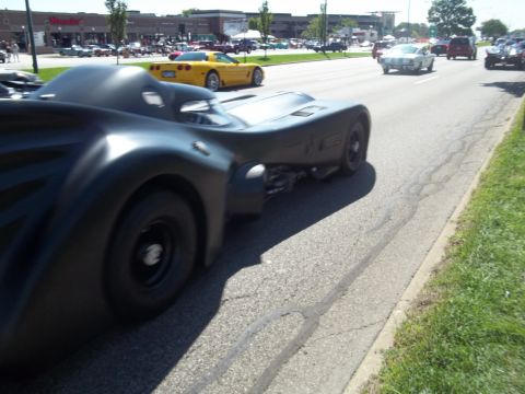 1970 Ford Ranchero - A custom Batmobile replica is seen driving on a street with other vehicles in the background.