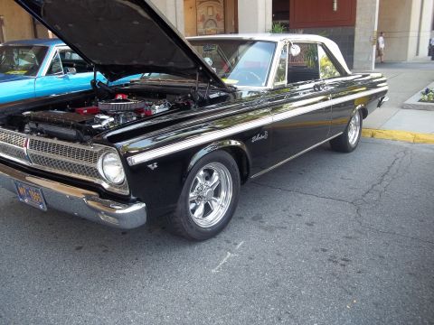 1970 Ford Ranchero - A black coupe with a white roof is parked outside, its hood open to reveal the engine, with another blue car visible behind it.