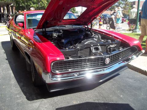 1970 Ford Ranchero - A red 1970 Ford Ranchero is displayed with its hood open, revealing the engine bay.