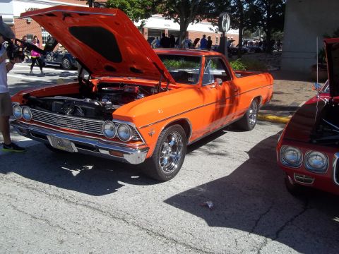1970 Ford Ranchero - An orange El Camino is displayed with its hood up, parked on a street next to another vehicle.