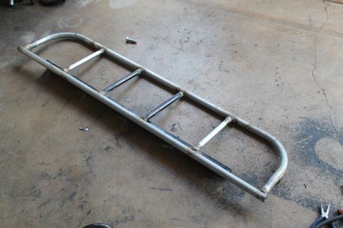 1990 Ford Bronco - Custom metal light cage with horizontal bars, shown on a concrete floor.