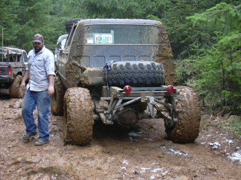 1991 Ford Bronco - This heavily modified truck is covered in mud after an off-road excursion with other vehicles.