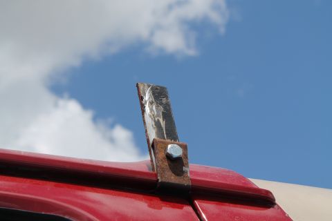 1990 Ford Bronco - Custom metal bracket attached to the roof of a vehicle against a blue sky.