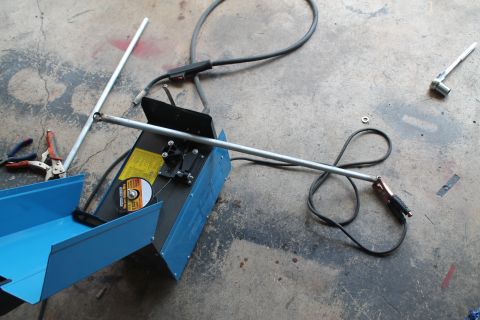 1990 Ford Bronco - Welding equipment and metal rods are laid out on a concrete surface, ready for use.
