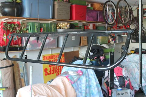 1990 Ford Bronco - A custom light cage is suspended in a garage, awaiting installation or modification.