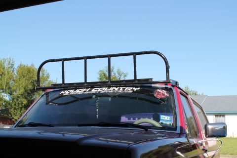 1990 Ford Bronco - Front view of an SUV with a roof rack and "Rough Country" sticker on the windshield.