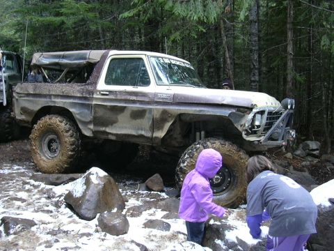 1991 Ford Bronco - This heavily modified 1978 Ford Bronco navigates a challenging off-road trail with snow on the ground.