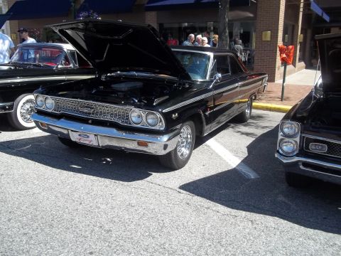 1970 Ford Ranchero - A classic black Ford Galaxie is displayed with its hood up at an outdoor event.