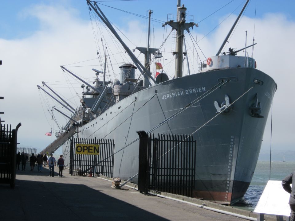 Ship named Jeremiah O'Brien docked at a pier with an 'OPEN' sign