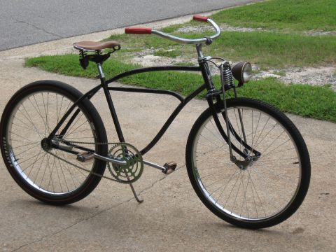 1994 Ford Bronco - A black cruiser bicycle with a brown saddle and red handlebars sits on a concrete driveway.