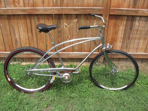 1994 Ford Bronco - This chrome cruiser bicycle has red-striped tires and is parked on grass.