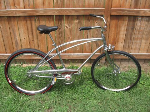 1994 Ford Bronco - A shiny cruiser bicycle with a classic design sits on the lawn next to a wooden fence.