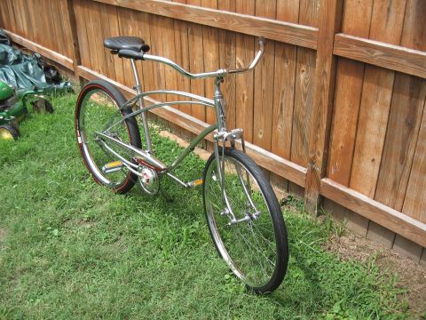 1994 Ford Bronco - A vintage-style bicycle rests against a weathered wooden fence on a grassy lawn.