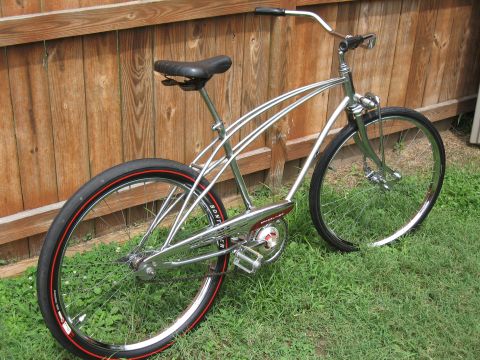 1994 Ford Bronco - A shiny chrome cruiser bicycle with red-striped tires is shown against a wooden fence.