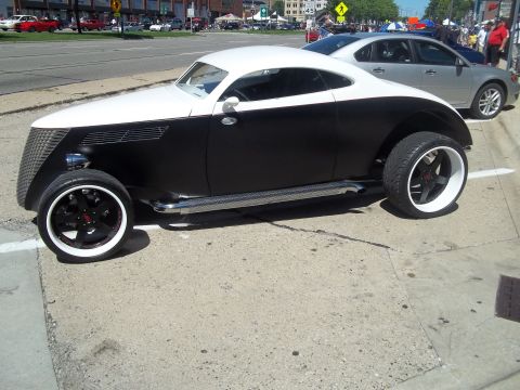 1970 Ford Ranchero - A custom hot rod with a distinctive two-tone paint scheme sits parked on a city street.
