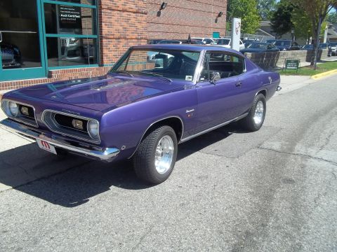 1970 Ford Ranchero - A purple Plymouth Barracuda is shown from a three-quarter front angle in front of a brick building.