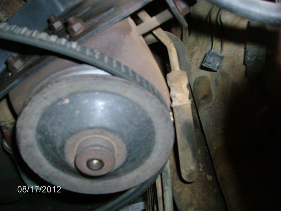 Close-up of a vehicle's engine pulley and belt system. A date stamp shows 08/17/2012