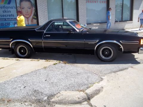 1970 Ford Ranchero - This black 1970 Ford Ranchero pickup truck is seen from the side, chrome accents and black wheels.