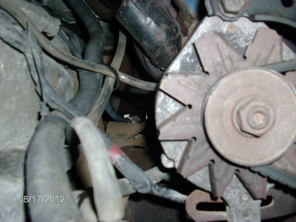 Close-up of an alternator and engine hoses with a date stamp of 08/17/2012