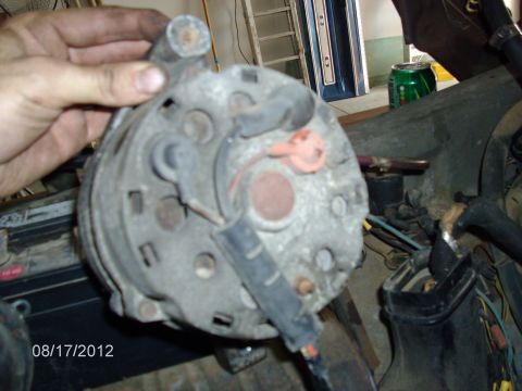 1979 Ford F-150 - A car alternator is held in a hand, with wiring and parts of the engine bay in the background. The date 08/17/2012 is visible.