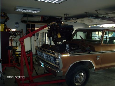 1979 Ford F-150 - An engine is being removed from a brown Ford truck using an engine hoist in a garage setting.