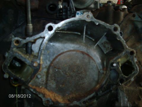 1979 Ford F-150 - Close-up of a corroded engine timing cover, showing signs of wear and tear.