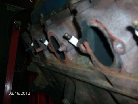 1979 Ford F-150 - Close-up of an engine block showing spark plugs inserted into exhaust ports.