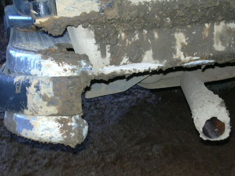1991 Ford Bronco - Mud-covered rear bumper and exhaust pipe of a vehicle, likely after off-roading.