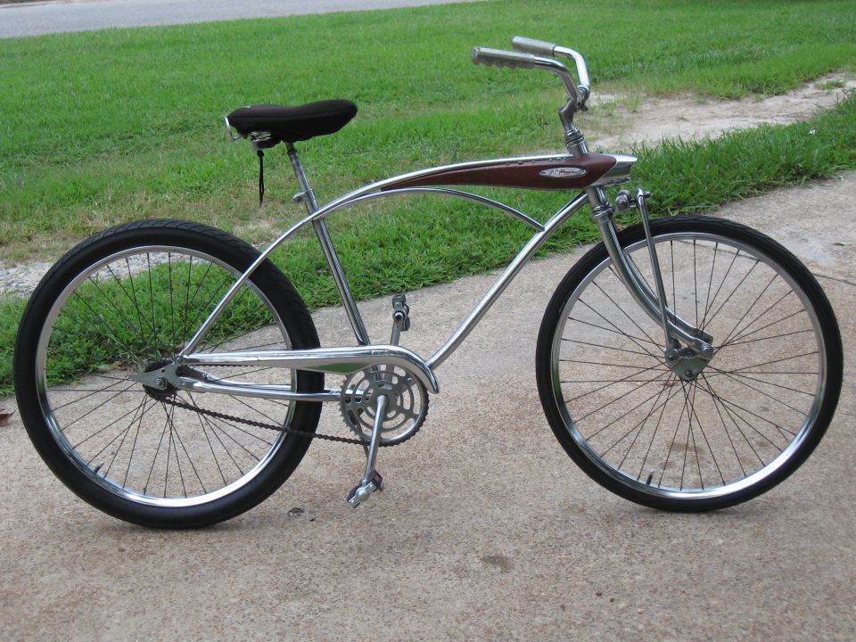 Chrome cruiser bicycle with a brown curved frame element and black seat