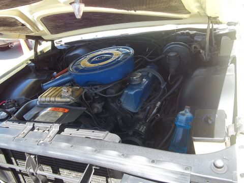 1970 Ford Ranchero - The engine bay of a vehicle is shown with the hood open, revealing the motor and various components.
