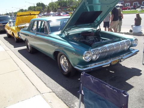 1970 Ford Ranchero - A teal 1963 Dodge Polara is parked on the street with its hood open, next to a yellow car.
