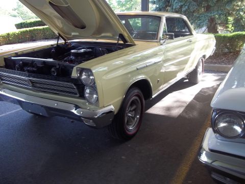 1970 Ford Ranchero - A vintage Mercury Comet is shown with its hood up, parked outdoors next to another vehicle.