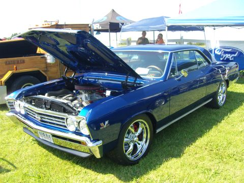2007 Ford Mustang - A blue 1967 Chevrolet Chevelle SS coupe is displayed with its hood open at an outdoor event.