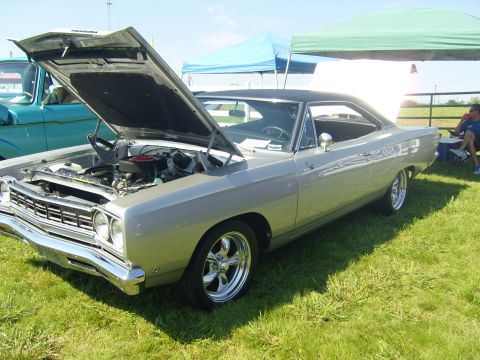 2007 Ford Mustang - A classic Plymouth Road Runner is displayed with its hood open at an outdoor event.