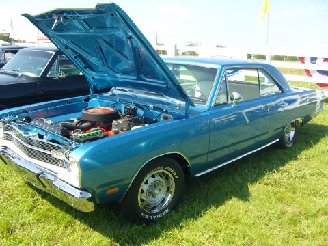 2007 Ford Mustang - A blue classic car is displayed with its hood open, revealing the engine compartment. Another vehicle is visible in the background.