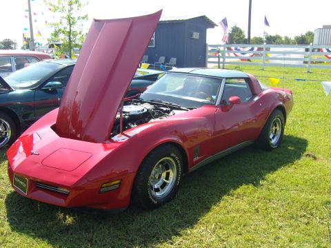 2007 Ford Mustang - A red Chevrolet Corvette is displayed with its hood open at an outdoor event.