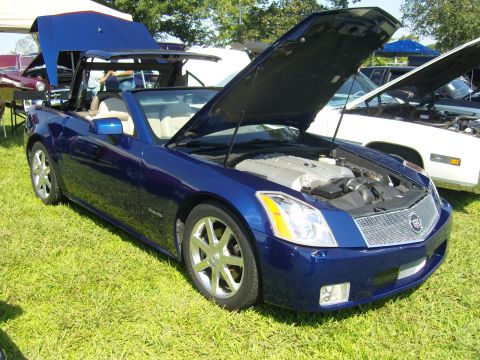 2007 Ford Mustang - A blue convertible is displayed with its hood and top open at an outdoor car show.