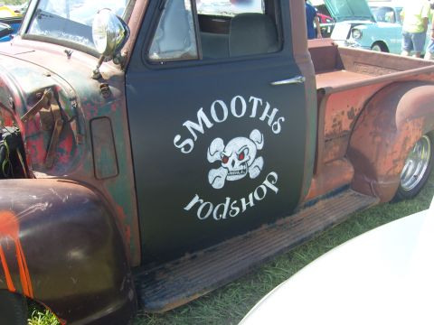 2007 Ford Mustang - A vintage pickup truck with custom "SMOOTHS rodshop" artwork on its door is seen at a car show.