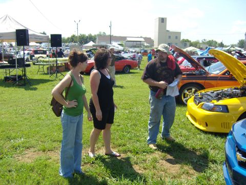 2007 Ford Mustang - A yellow Ford Mustang is displayed at an outdoor car show.