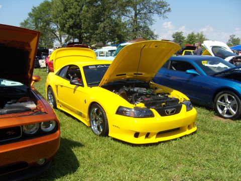 2007 Ford Mustang - A yellow Ford Mustang is displayed with its hood open at an outdoor car show.