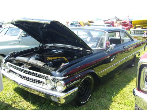 2007 Ford Mustang - A classic black 1960 Ford Falcon is displayed with its hood open at a car show event.