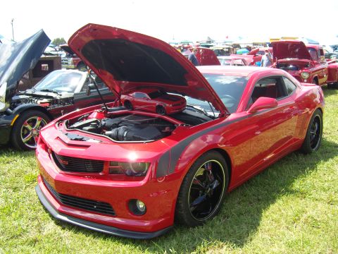 2007 Ford Mustang - A red Chevrolet Camaro is displayed with its hood open, revealing the engine and a miniature replica of the car.