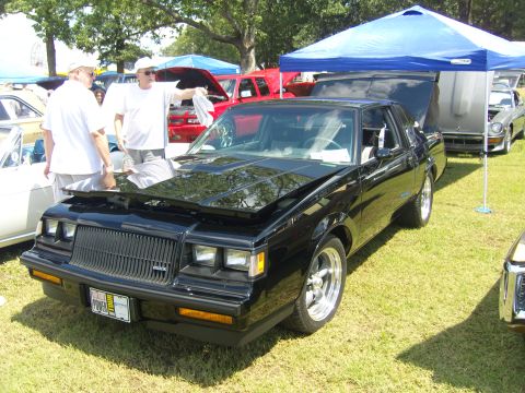 2007 Ford Mustang - A black coupe is displayed with its hood open at an outdoor car show.