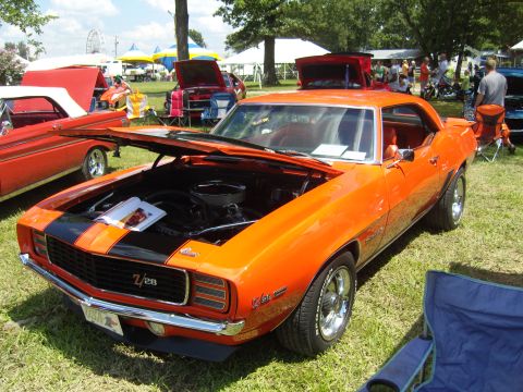 2007 Ford Mustang - This orange 1969 Chevrolet Camaro Z/28, with its hood open, is displayed at an outdoor car show.