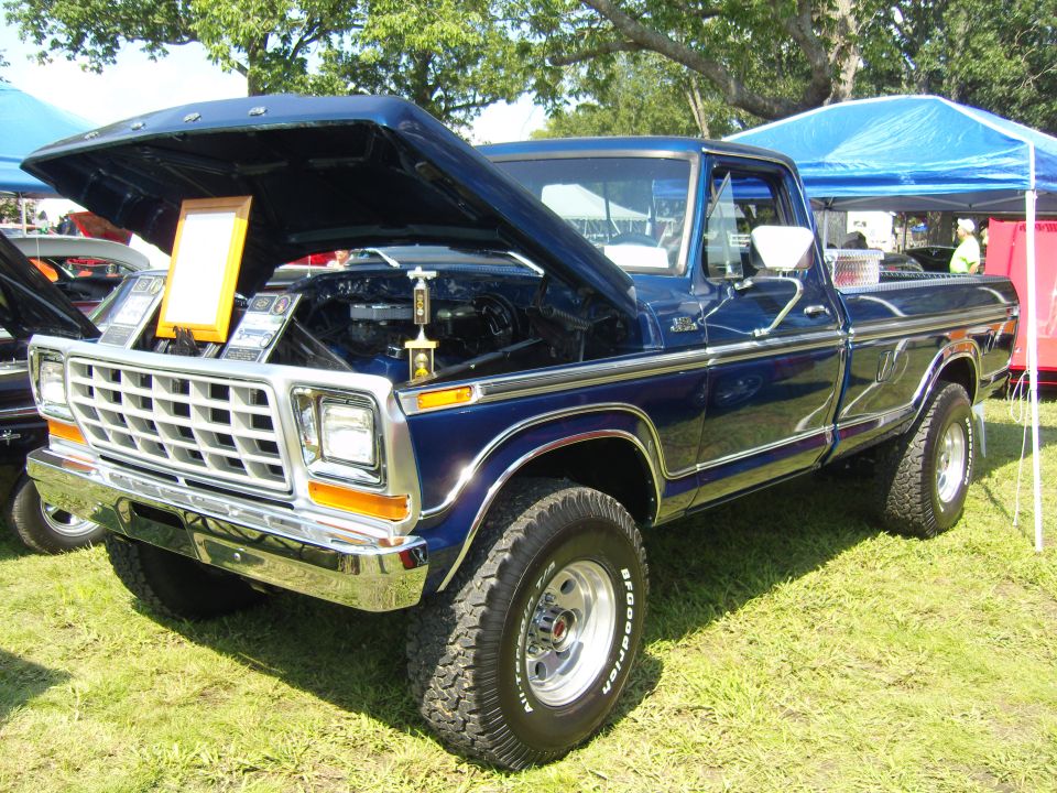 Blue 1977 Ford F-Series pickup truck with hood open, showing engine and trophy