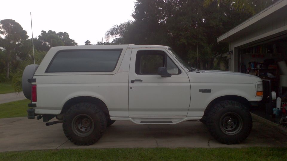 White 1995 Ford Bronco side view with spare tire on rear